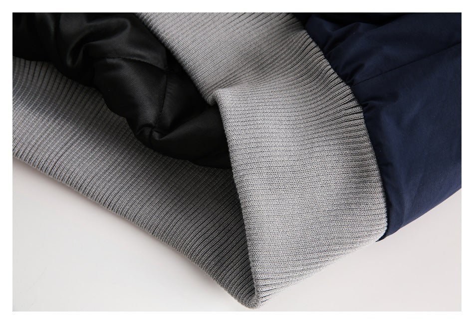 Close-up of a navy jacket's gray ribbed cuff and black inner lining.