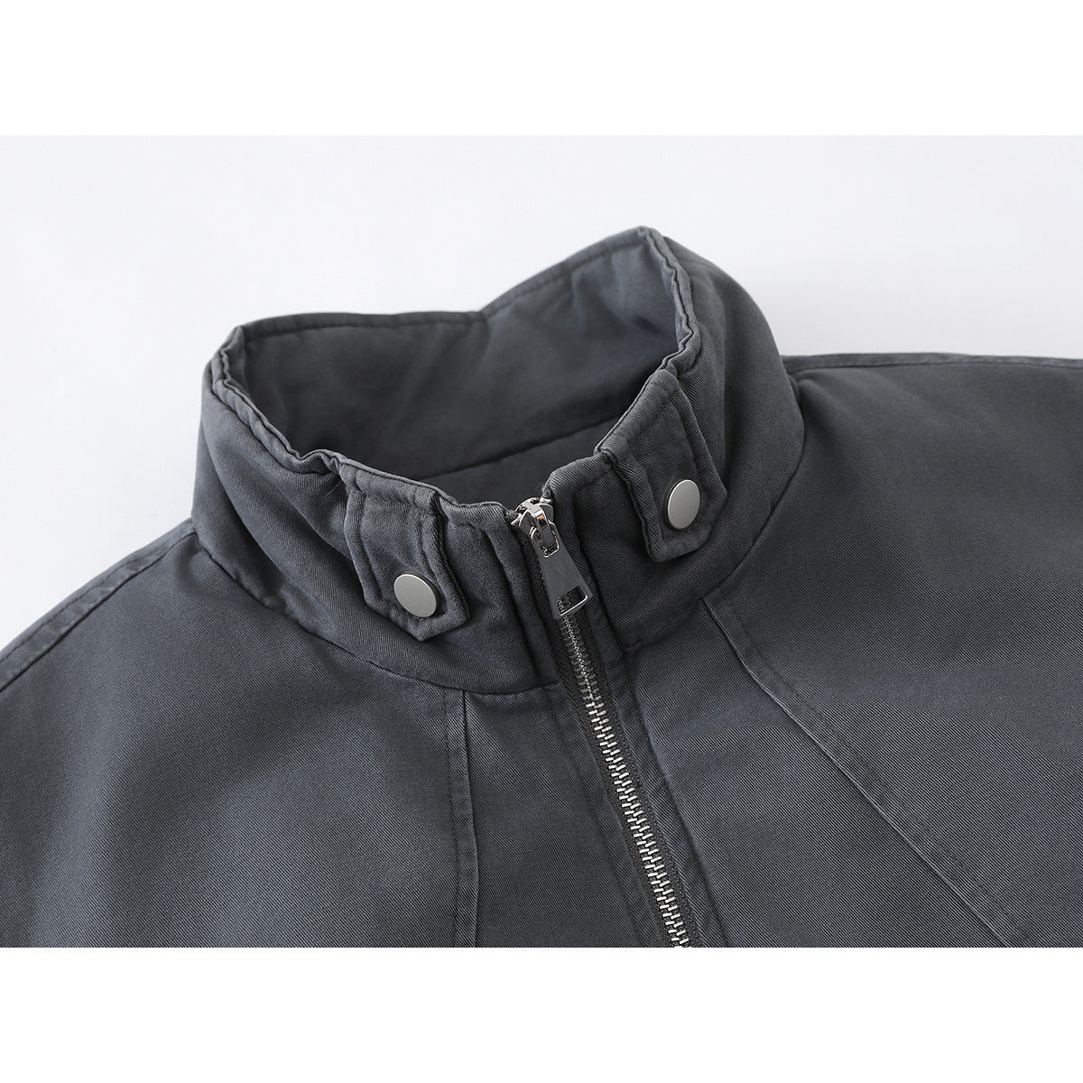 Close-up of a charcoal jacket's stand collar, snap tabs, and silver front zipper.