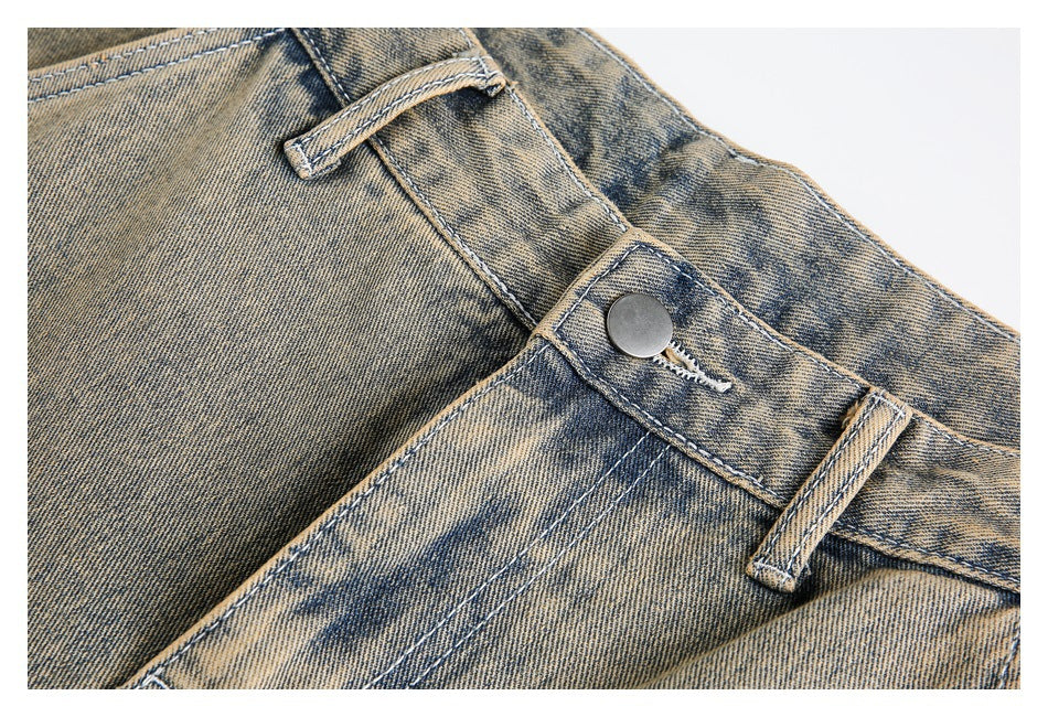 Close-up of the metal waist button, belt loop, and distressed wash on tan jeans.