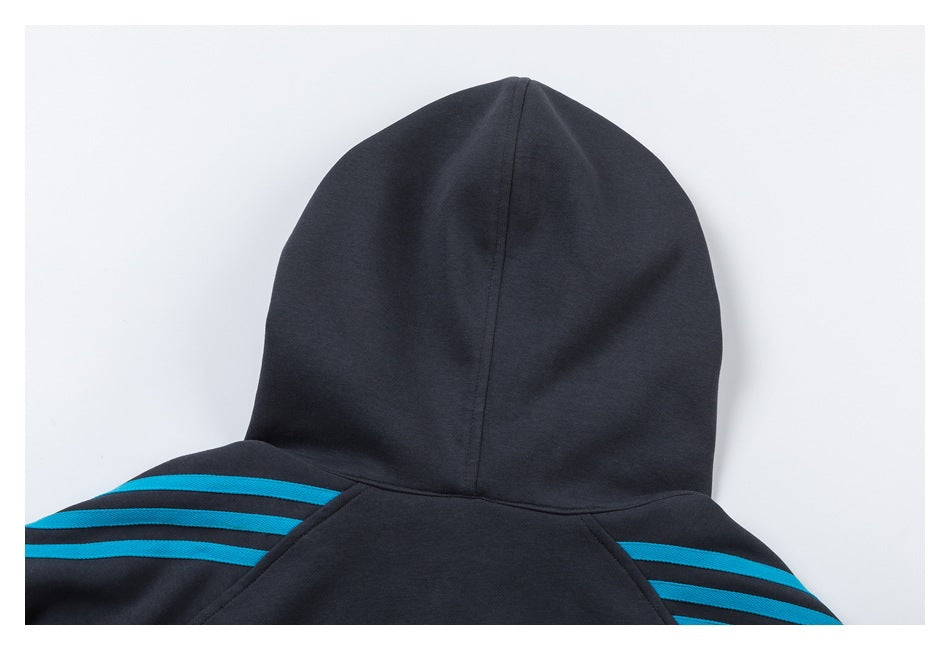 Close-up of a dark hoodie’s back hood and shoulders, with bright blue stripes across the shoulders.