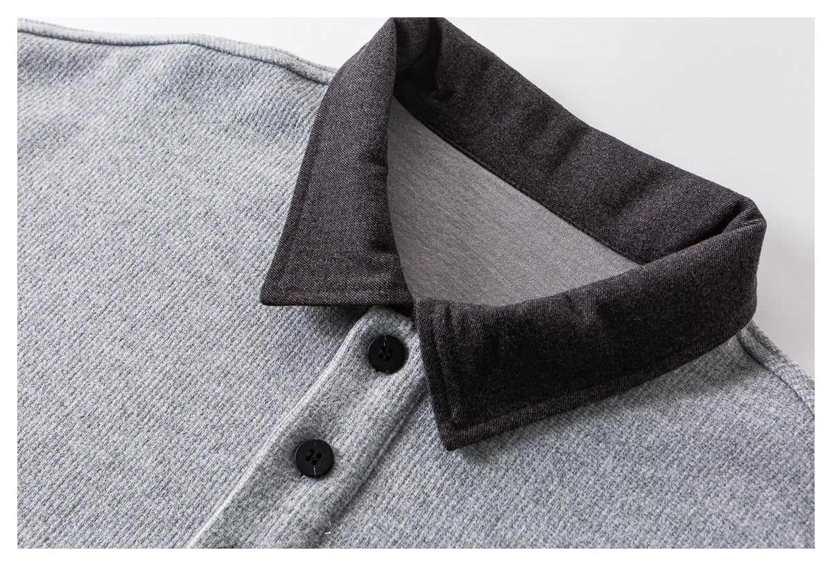 Close-up of a light gray textured shirt with a dark charcoal collar and black buttons.