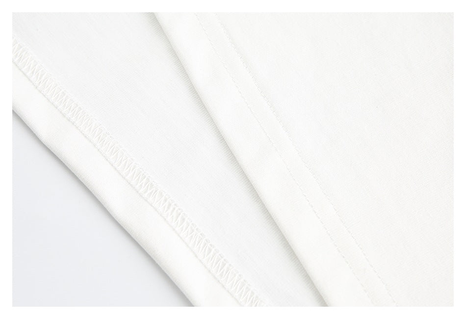 Close-up of white fabric showing an overlocked seam and straight stitching.