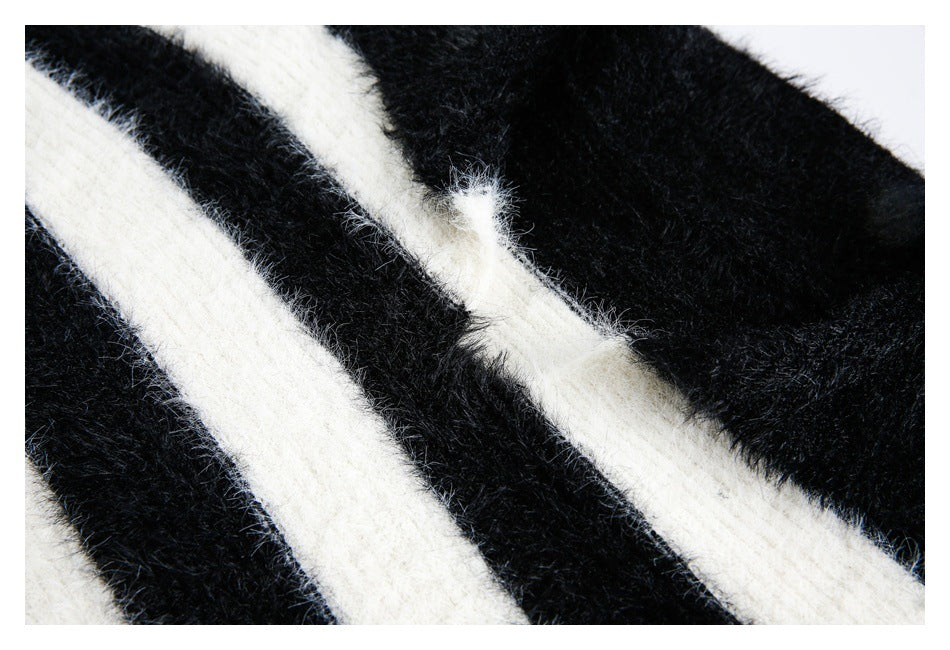 Close-up of fuzzy black knit with wide diagonal ivory stripes.