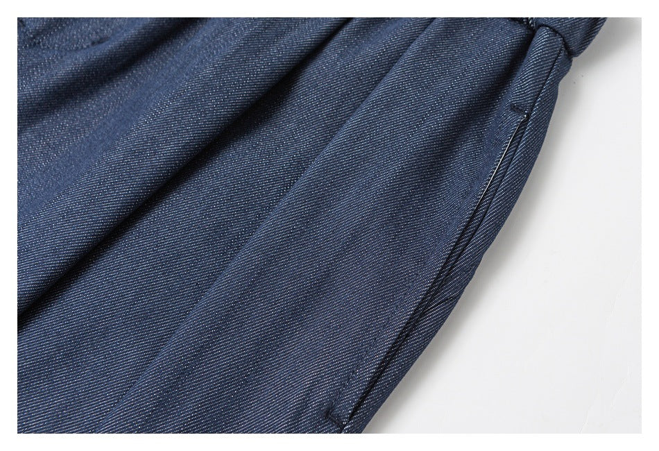 Close-up of navy trouser fabric and a stitched side pocket opening.