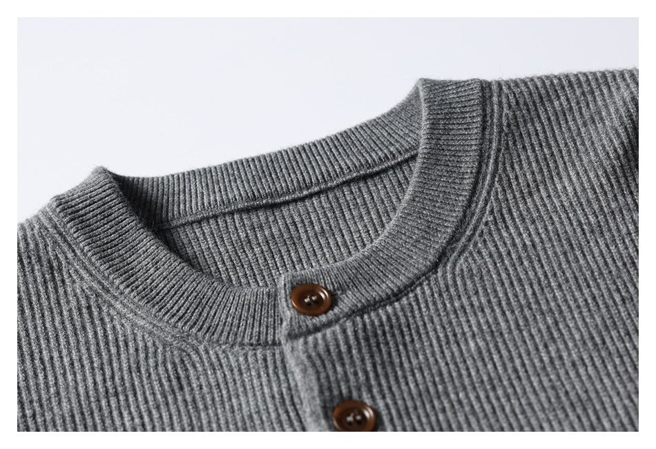 Close-up of the gray rib-knit sweater's crew neckline and brown-button placket.