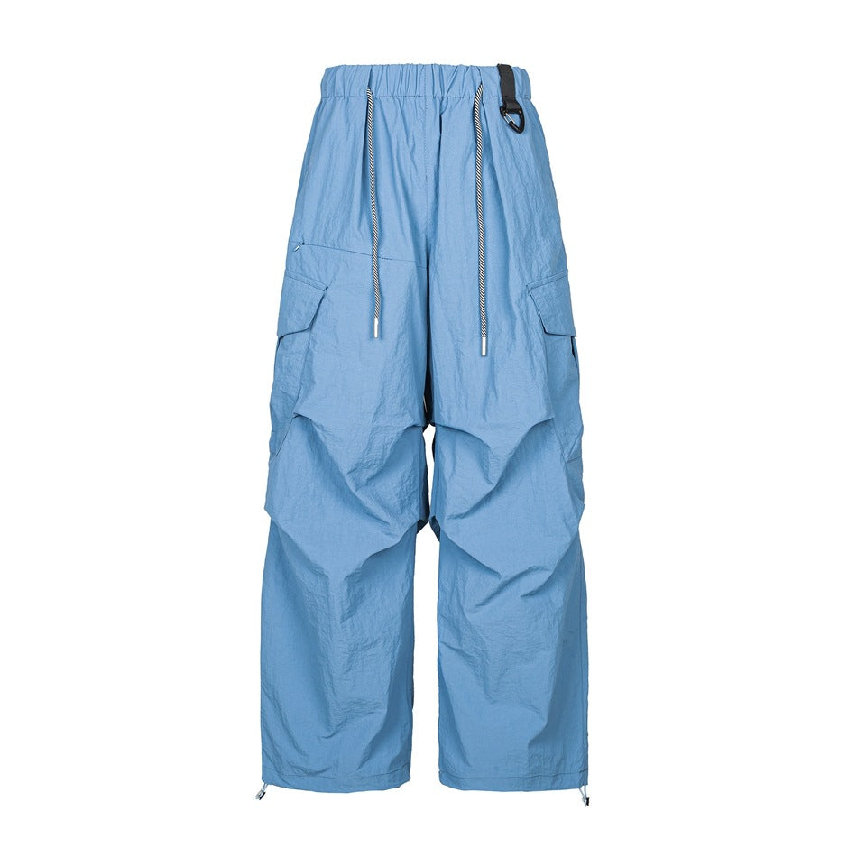 Blue wide-leg cargo pants with elastic waist, striped drawcord, side flap pockets and knee pleats, front view