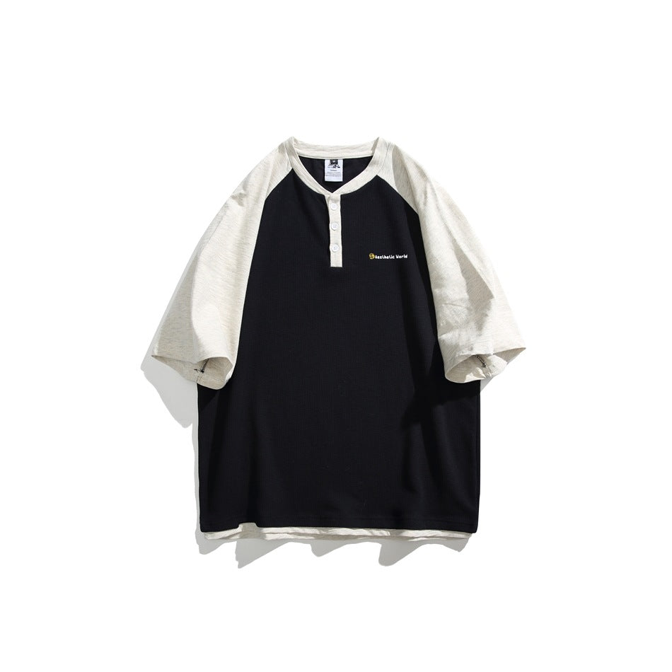 Black Henley T-shirt with off-white raglan sleeves, three white buttons and small chest print, flat lay