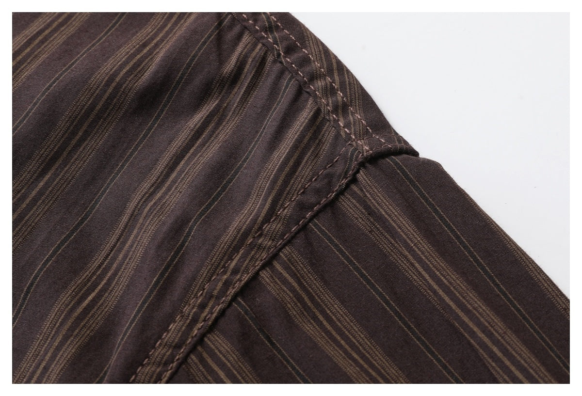 Close-up of the striped dark brown shirt's shoulder seam and stitching.