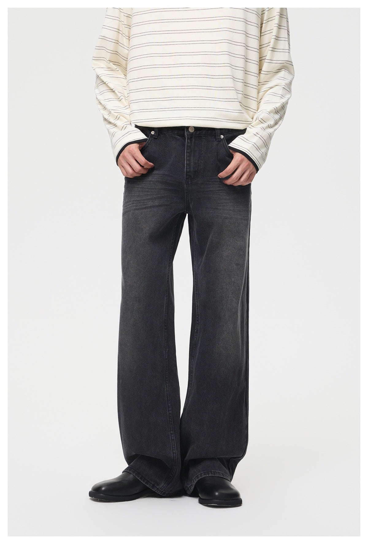Model wearing faded black wide-leg jeans with hands in pockets, striped long-sleeve top and black leather shoes