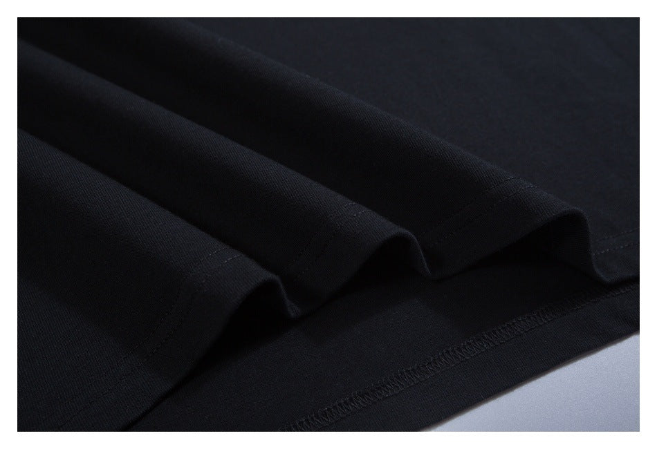 Close-up of folded black T-shirt fabric and the stitched bottom hem.
