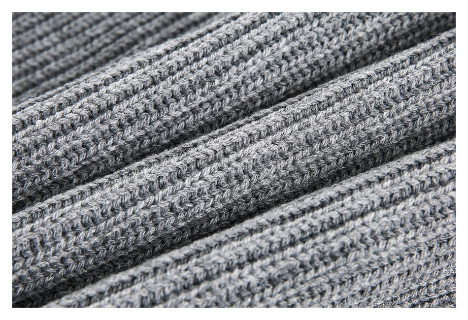 Close-up of gray knit fabric showing a thick, textured ribbed stitch pattern.