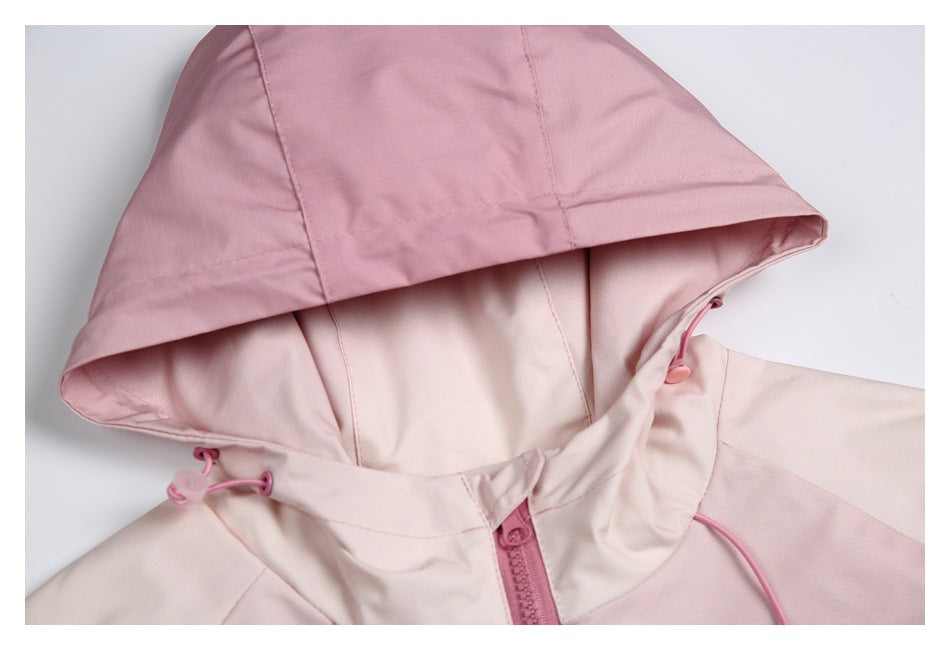 Close-up of a pale pink jacket hood with pink drawcords, toggles, and a front zipper.