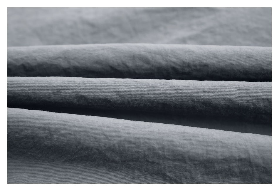 Macro view of folded dark gray jacket fabric showing its surface texture.