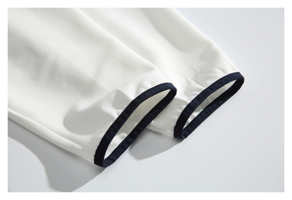 Close-up of white garment sleeves with dark navy edging along the cuffs.
