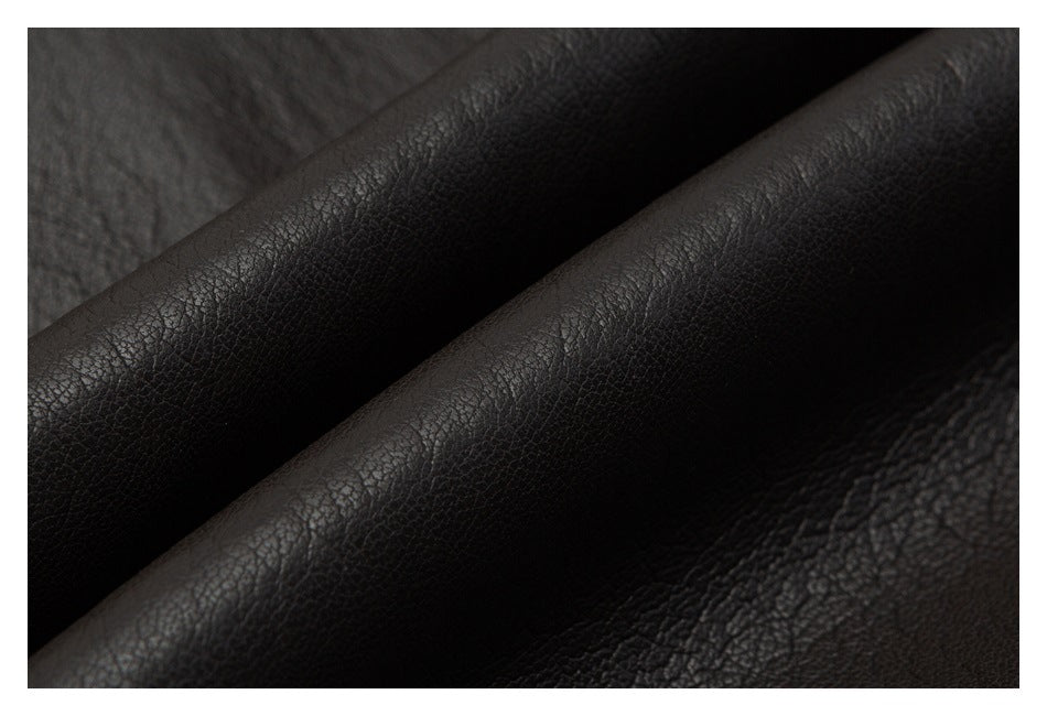 Extreme close-up of the dark brown jacket's pebbled leather-look surface and folded edge.