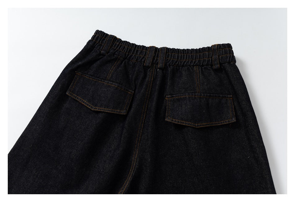 Back view of black denim pants laid flat, with an elastic waistband, belt loops, and two flap pockets.