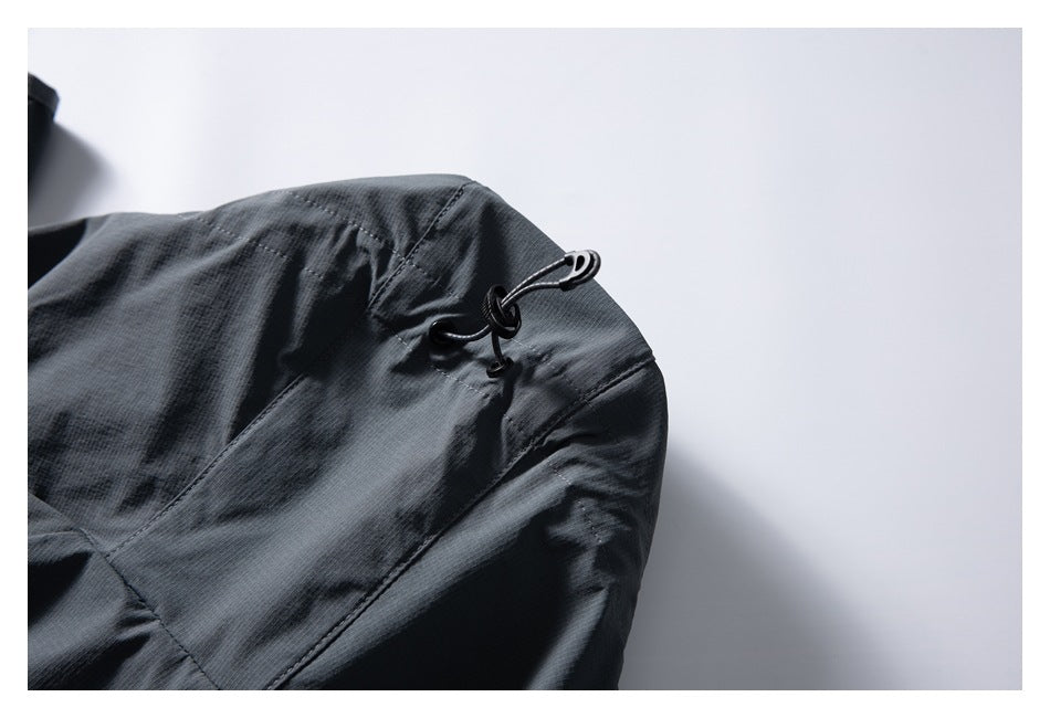 Close-up of a dark gray jacket hood with a black cord and adjustment toggle.