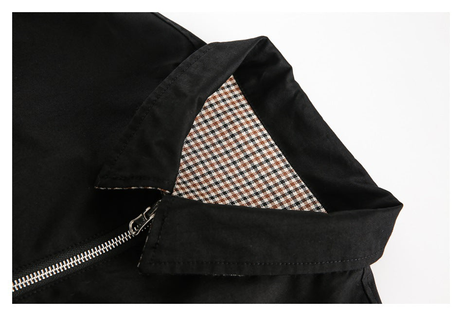 Close-up of a black jacket collar showing check-pattern lining and the metal zipper.
