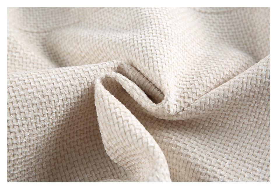 Close-up of the cream woven garment's raised texture and soft folds.