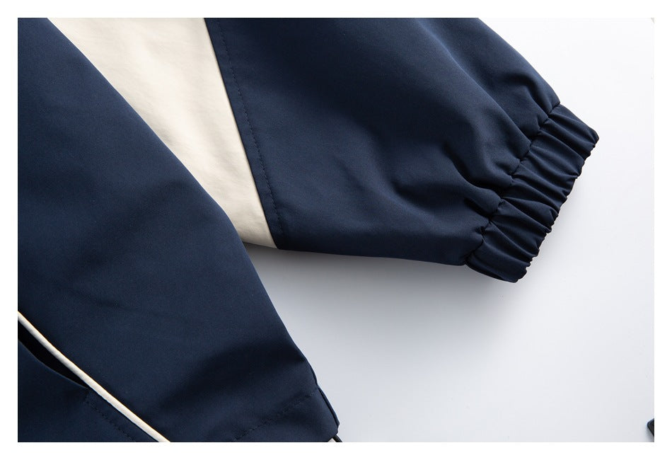 Close-up of a navy jacket sleeve with a gathered elastic cuff and cream contrasting panel.