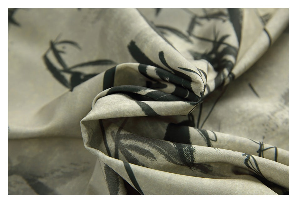 Close-up of draped beige fabric with an abstract black and gray print.