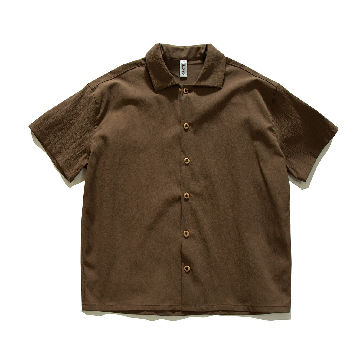 Brown short-sleeve button-up shirt with turn-down collar and triangular-cutout buttons, flat lay front view