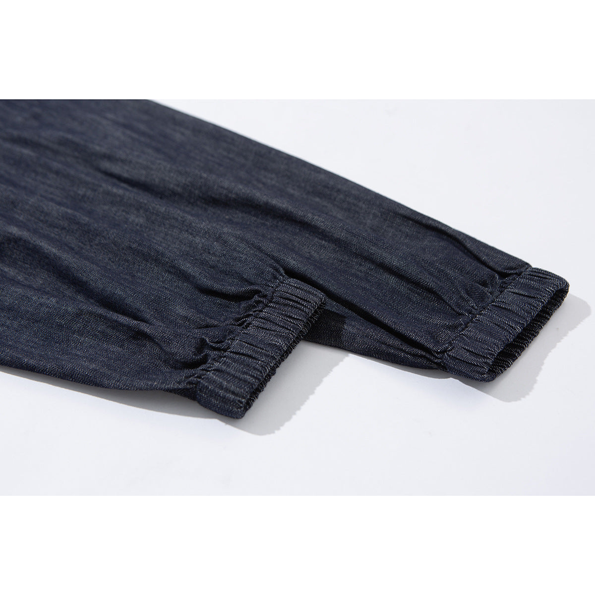 Close-up of a dark indigo jacket sleeve with an elasticated cuff.