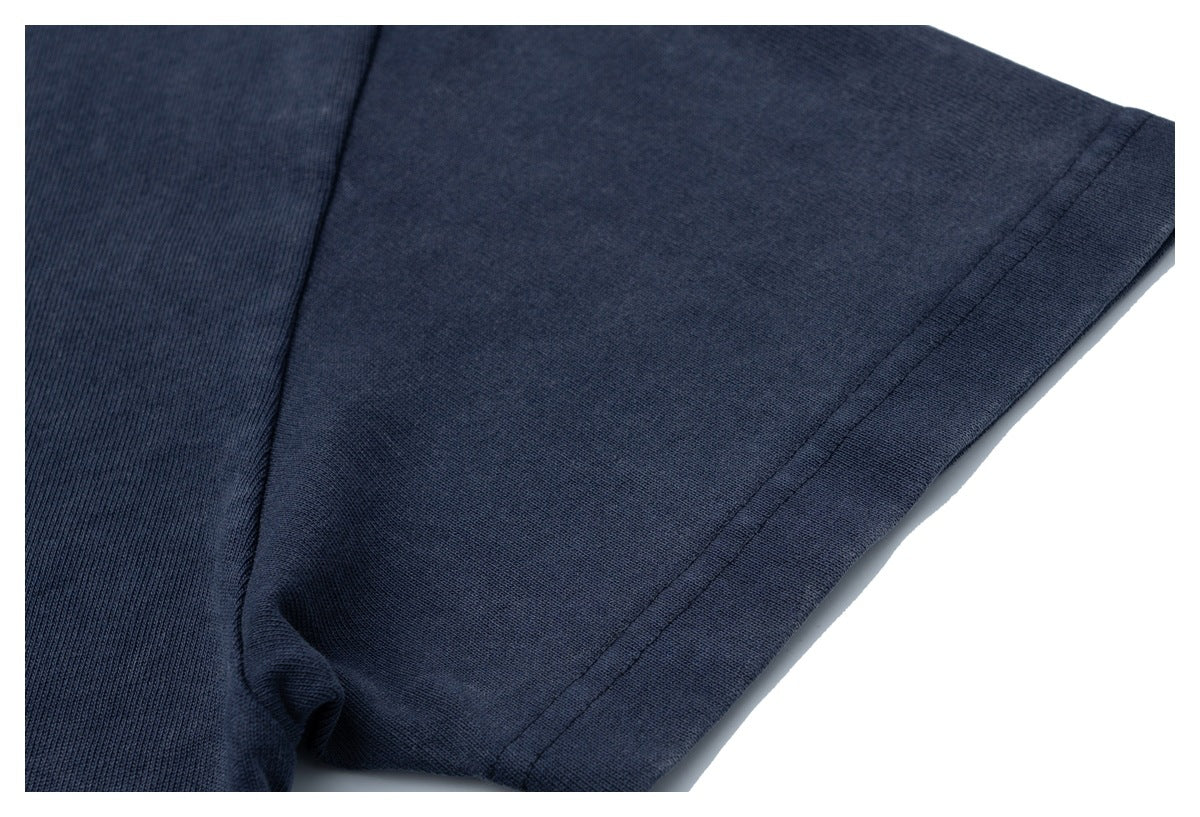 Close-up of the navy T-shirt's short sleeve, showing the sleeve seam and hem.