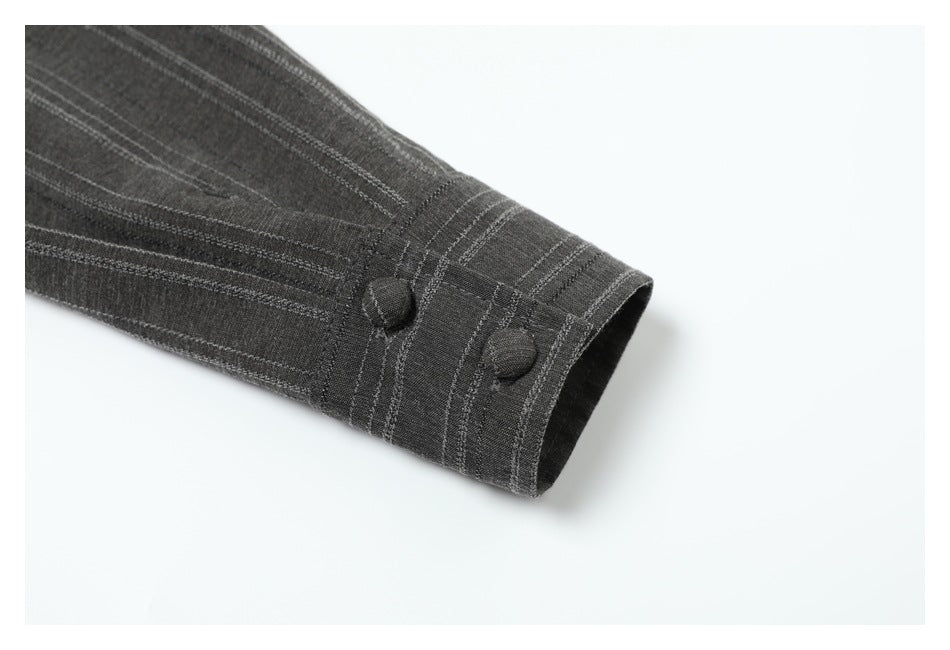 Close-up of a charcoal gray striped sleeve cuff with two fabric-covered buttons.