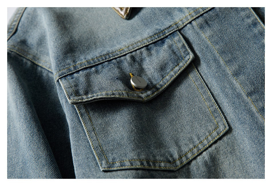 Close-up of a denim jacket pocket flap with a dark button and yellow topstitching.