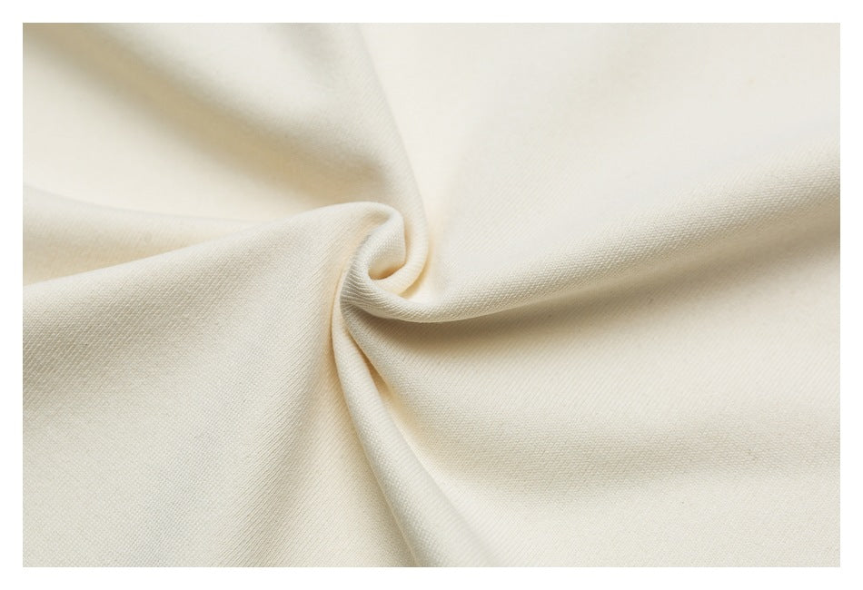 Close-up of ivory fabric gathered into a soft twist, showing its fine surface texture.