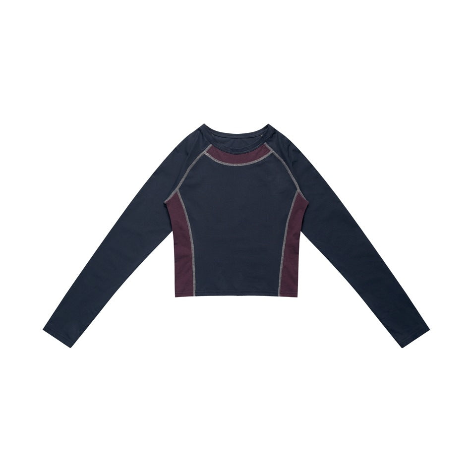 Navy cropped long-sleeve raglan top with purple collar and side panels and contrast stitching, flat lay