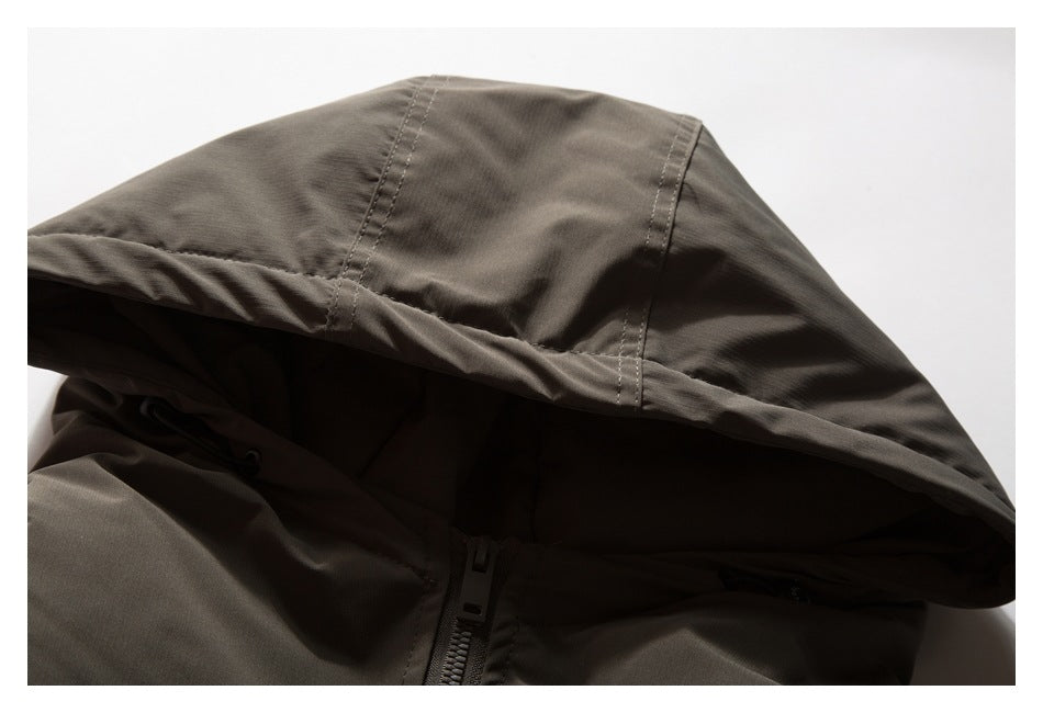 Close-up of a charcoal-brown jacket hood, stitching, drawcord, and front zipper.