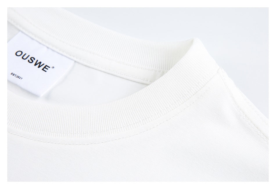 Close-up of the ribbed crew neckline and sewn brand label on a white T-shirt.
