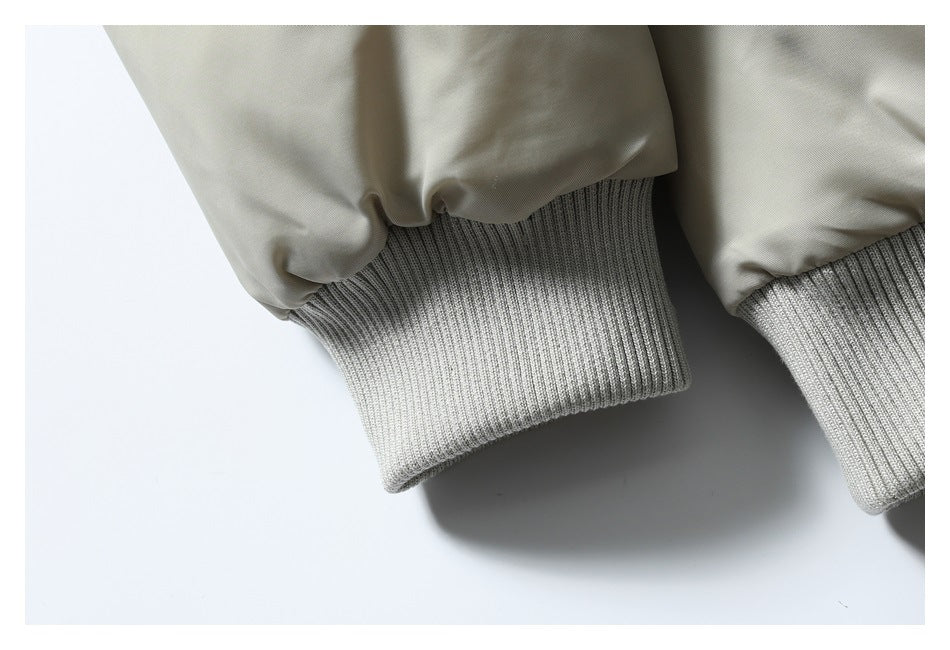 Close-up of the jacket's light beige sleeves and wide gray rib-knit cuffs.