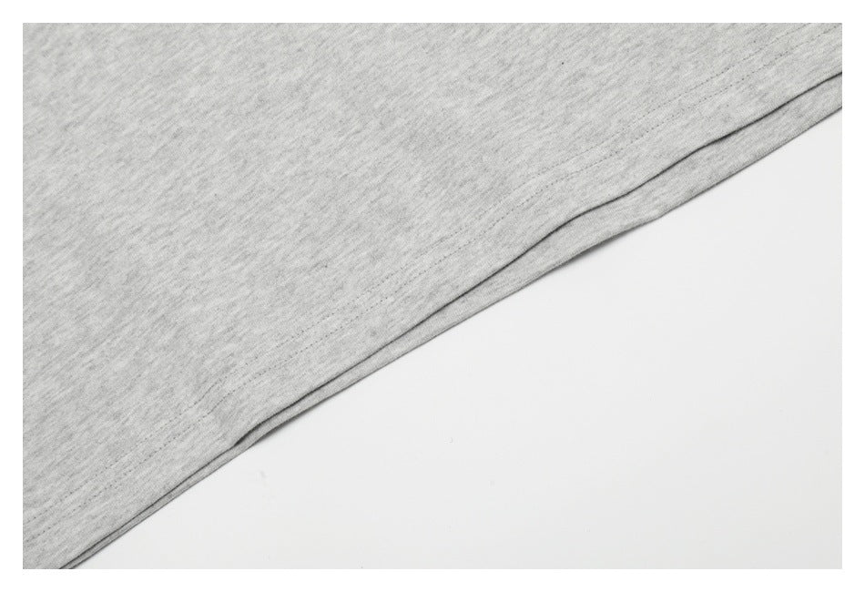 Close-up of a light heather-gray garment hem with a neat stitched edge.