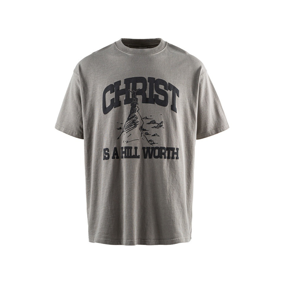 Gray washed short-sleeve crew-neck T-shirt with black 'CHRIST IS A HILL WORTH' hill graphic, flat front view