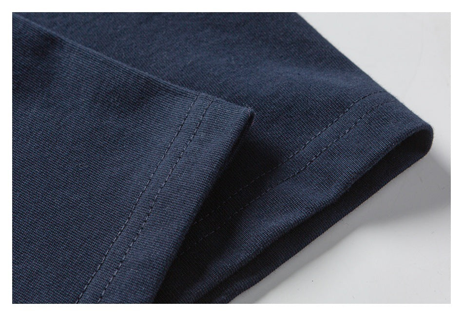 Close-up of the navy T-shirt sleeve hem and double-row stitching.
