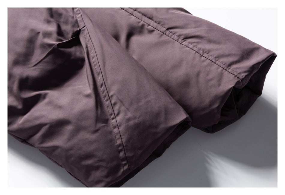 Close-up of the dusty mauve garment's stitched lower edge and folded hem.