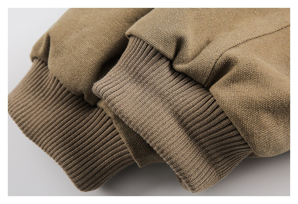 Close-up of tan garment fabric gathered over ribbed knit cuffs or hem.