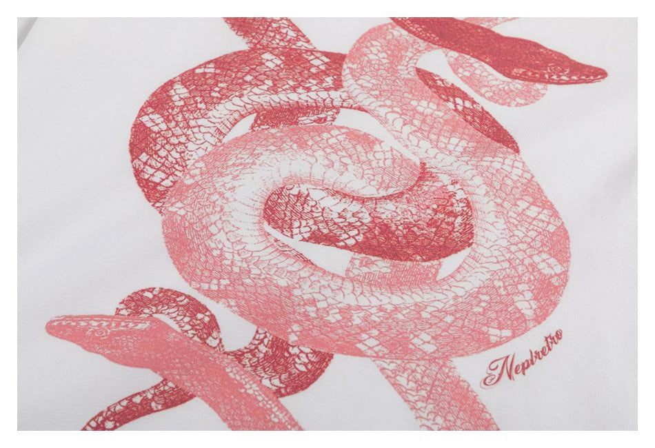 Close-up of the T-shirt's red intertwined-snake print on white fabric.