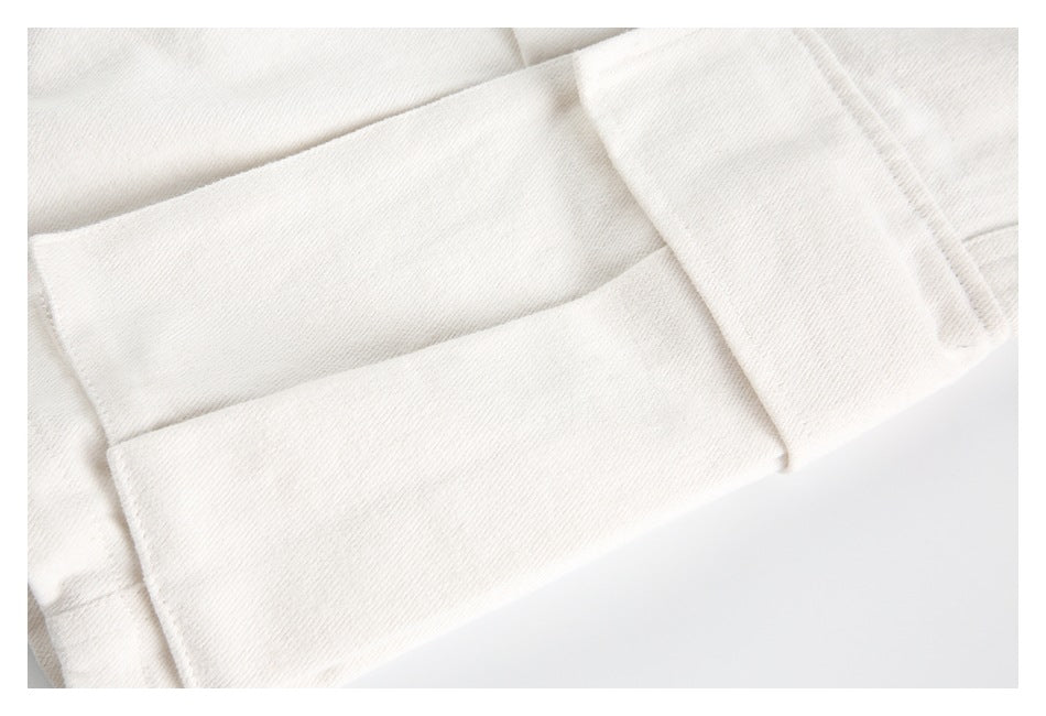 Close-up of an ivory garment with layered folded fabric and stitched seams.