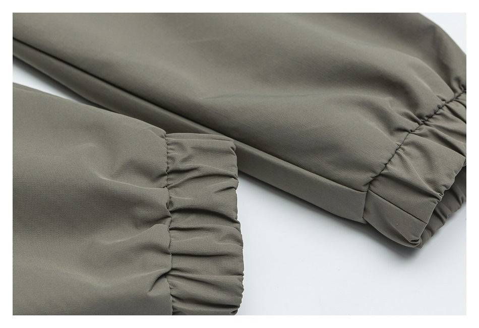 Close-up of olive-gray jacket sleeves and gathered elastic cuffs.
