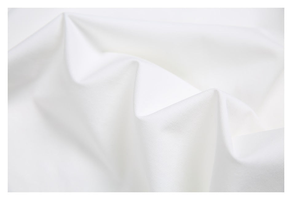 Close-up of white fabric draped in soft folds, showing its surface texture.