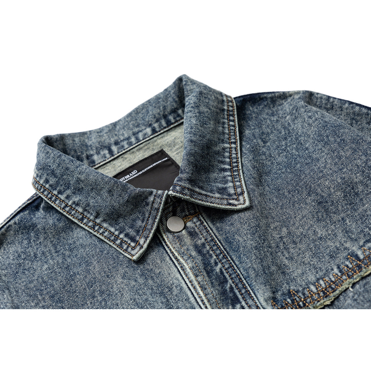 Close-up of a blue acid-wash denim jacket collar, metal snap, and button placket.