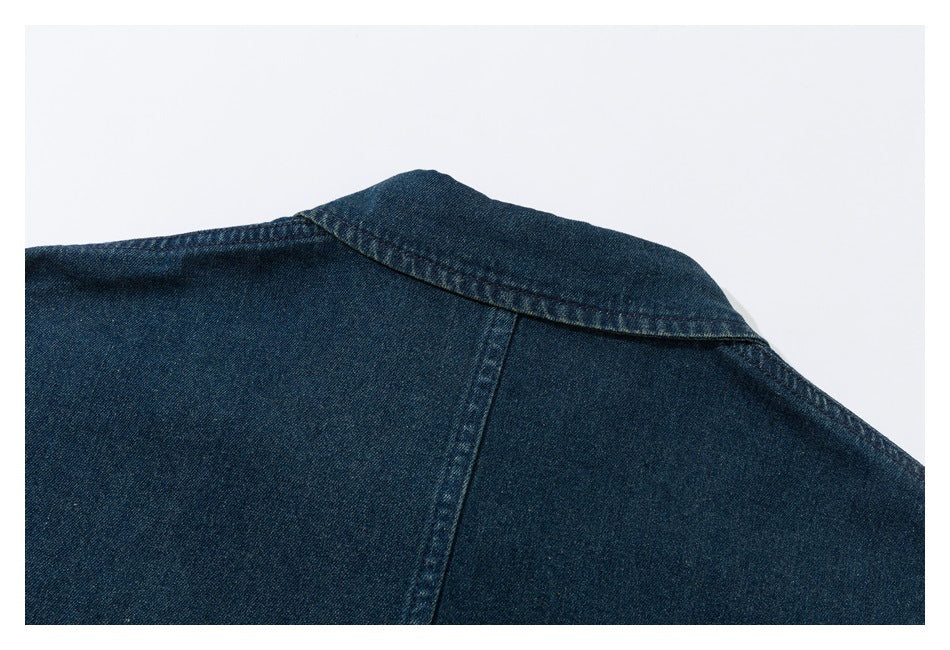 Close-up of a dark blue denim shirt collar and shoulder seam.