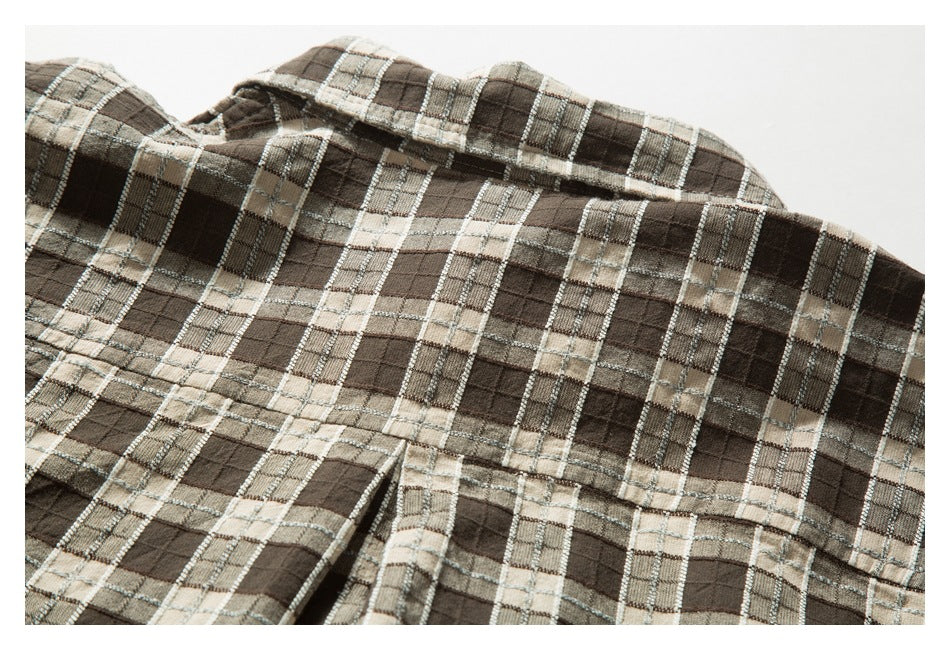 Close-up of a brown and beige plaid garment collar and seams.