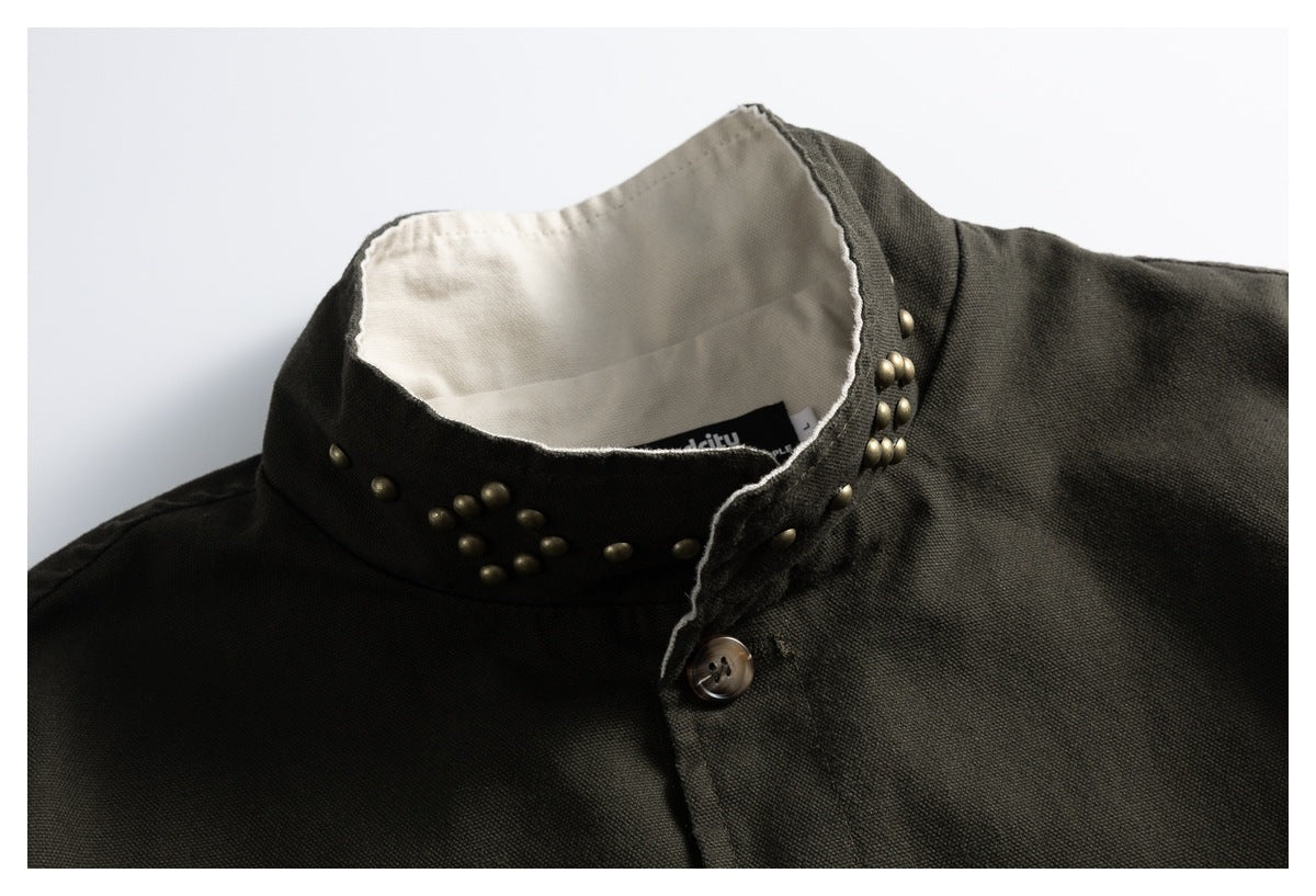 Close-up of a dark olive jacket collar with brass studs, cream lining and a partly visible inner label.