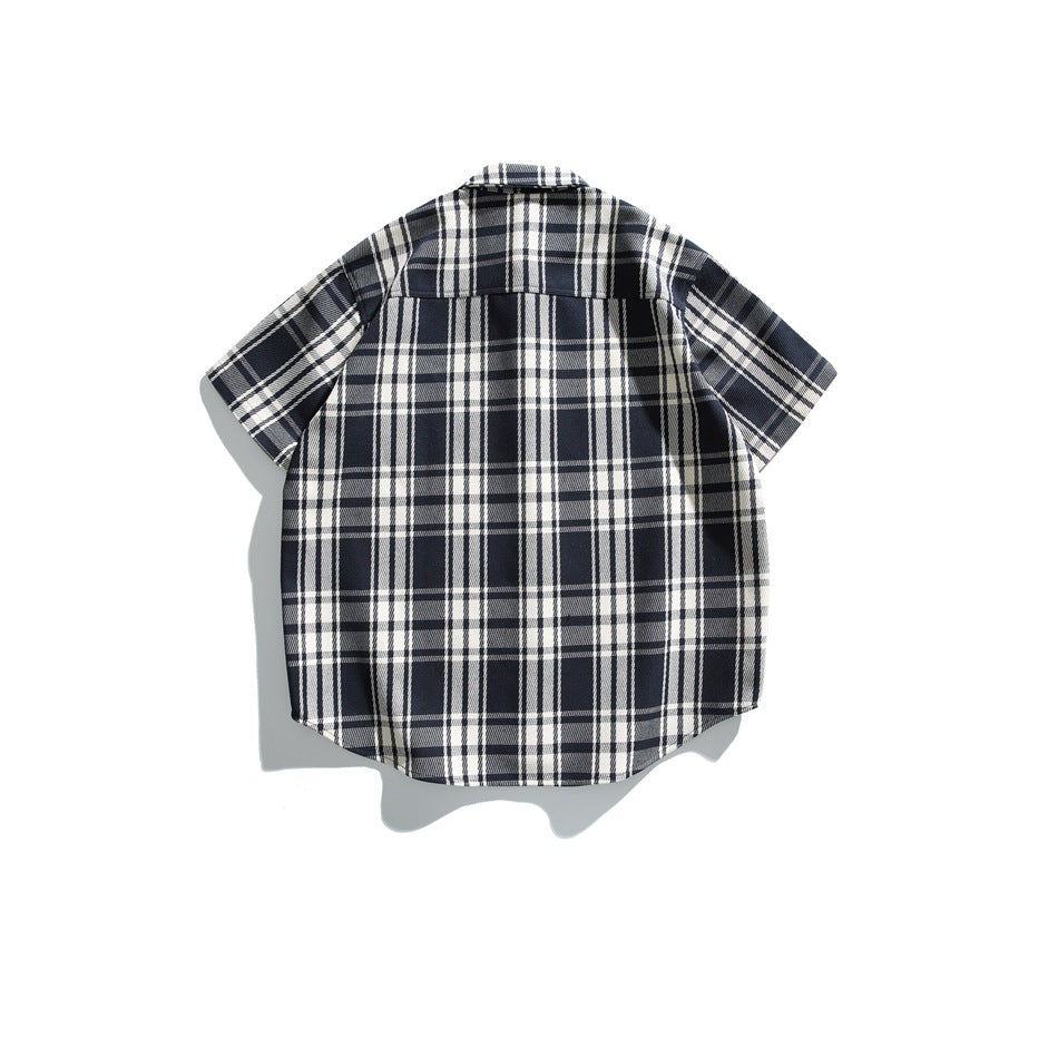 Back view of a navy and white plaid short-sleeve button-up shirt laid flat.