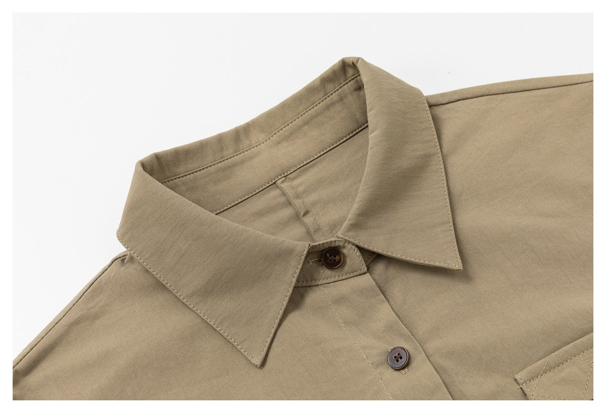 Close-up of the khaki shirt's pointed collar, neckline, stitching, and upper buttons.